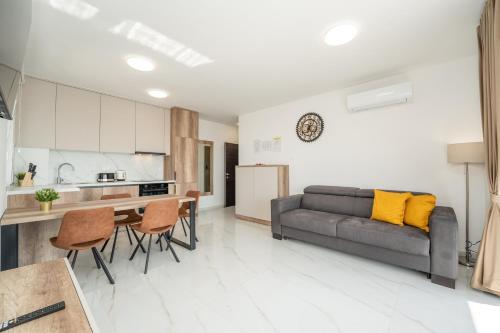 a kitchen and living room with a couch and a table at Poolside Hideout Apartments in Novalja