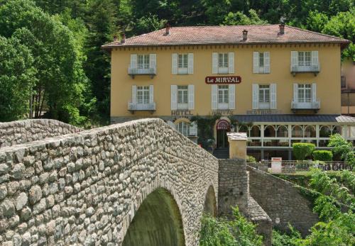 un vieux pont en pierre avec un bâtiment en arrière-plan dans l'établissement Le Mirval, à La Brigue