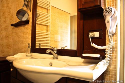 a bathroom with a white sink and a phone at Albarosa in Ruvo di Puglia