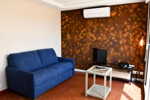 un salon avec un canapé bleu et une télévision dans l'établissement Appartement deux pièces au bord de la plage, au Barcarès
