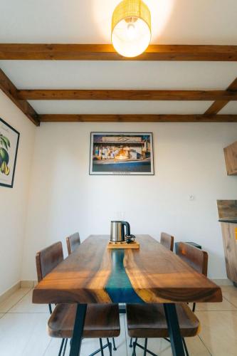 a dining room with a wooden table and chairs at Les Ti Kaz d'Auguste in Les Avirons