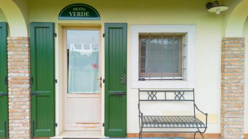 a bench sitting outside of a house with a door at breathtaking lake view and pool, Prato Verde in Barcuzzi