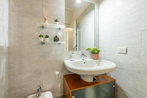 un baño con lavabo y espejo en Deluxe & Elegant Apt with all Comfort and View, en Milán