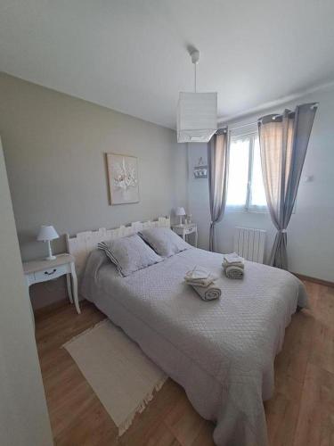 une chambre blanche avec un grand lit et une fenêtre dans l'établissement La belle etoile, à Saint-Aulaye