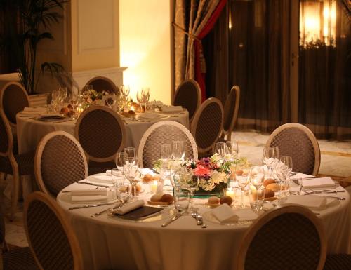 a table with white tablecloths and flowers on it at Grand Visconti Palace in Milan
