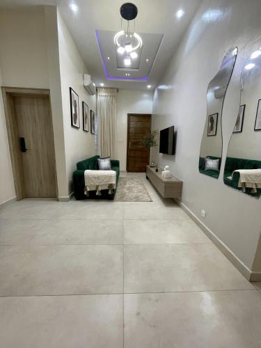 a living room with a green couch and a tv at EliteunseenSuites - 5 Bedroom Beautiful Detached House - Private Parking in Lekki