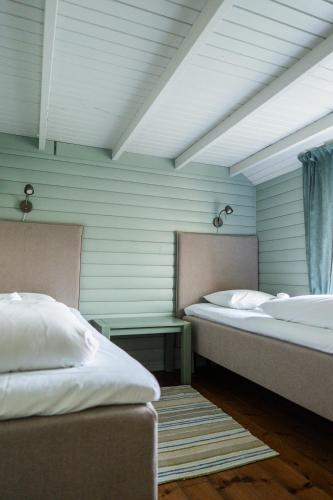 two beds in a room with blue walls at Eliassen Rorbuer in Reine