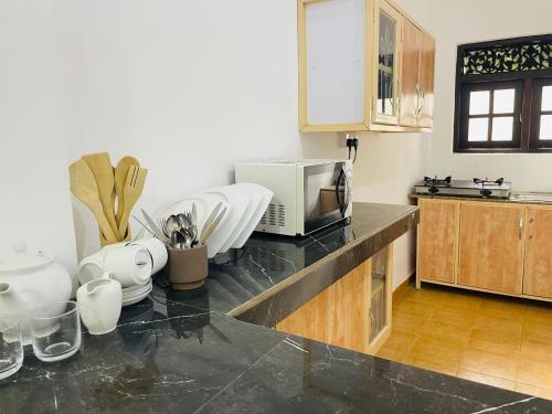 a kitchen with a counter top with a microwave at Sholay Villa in Galle