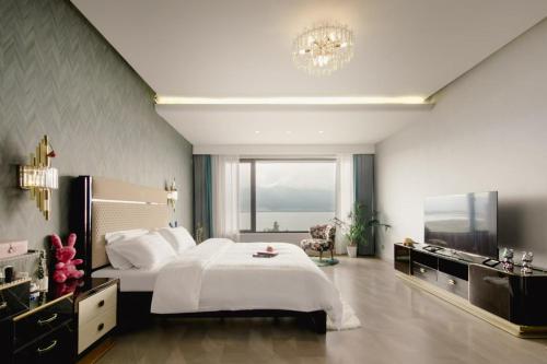 a large bedroom with a bed and a television at 慢境Slow Land半山海景花园酒店 in Dali