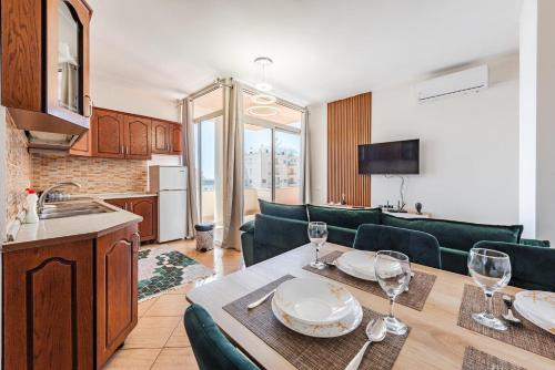 una cucina e un soggiorno con un tavolo con bicchieri da vino di Seaside Escape a Durrës