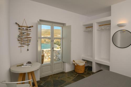 a white room with a table and a window at Amorgos Elegant Houses, 6 Villas in Amorgos