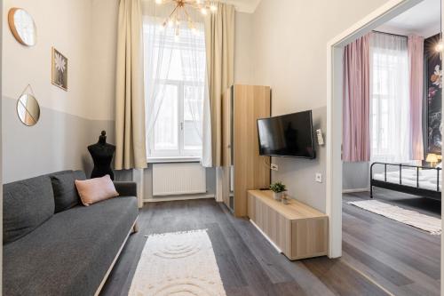 Una sala de estar con un sofá y un televisor. en W33 - Prime Location - Comfortable Quality Apartments by BQA, en Budapest