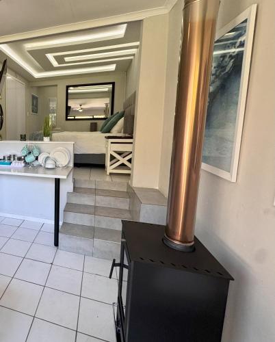 a living room with a sink and a bed at Footprints Self Catering Indoor Heated Pool and Fireplaces in Lanseria