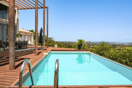 une piscine sur une terrasse à côté d'une maison dans l'établissement Les Hauts d'Avignon, à Rochefort-du-Gard
