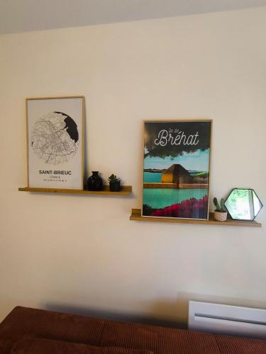two shelves on a wall with two pictures on it at L'Echappée Urbaine - 2 personne proche - centre ville in Saint-Brieuc