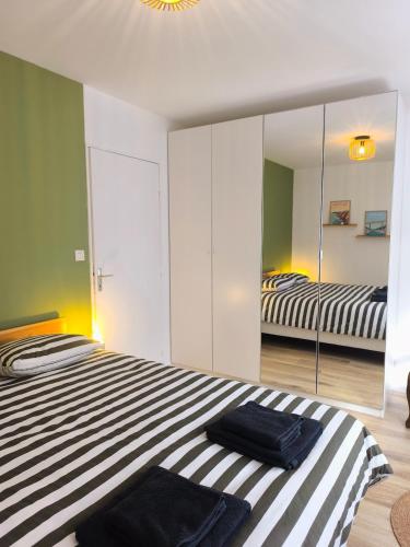 a bedroom with two beds and a large mirror at L'Echappée Urbaine - 2 personne proche - centre ville in Saint-Brieuc