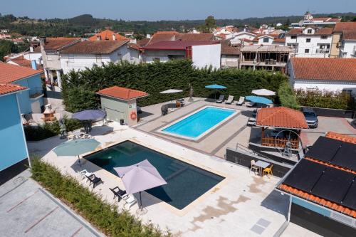 an overhead view of a swimming pool with umbrellas at Villa Montês - Exclusive Apartments & Prime Location in Coja