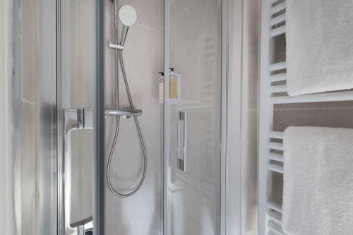 a shower with a glass door in a bathroom at Seb & Co in Paris