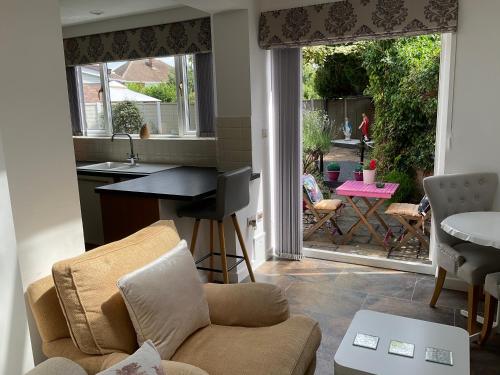 a living room with a couch and a table and a kitchen at Oakleigh 1 bed ground floor garden view apartment FREE ONSITE PARKING in Stratford-upon-Avon