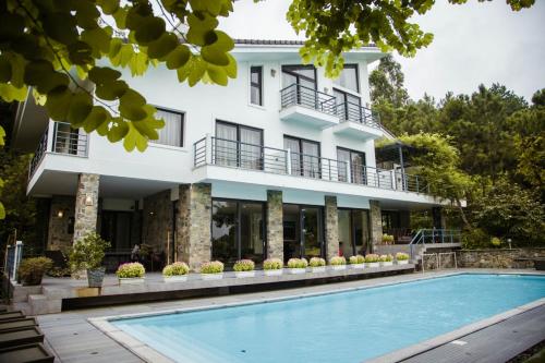 un hôtel avec une piscine devant un bâtiment dans l'établissement YenYen Villa - 2000m2 villa in Tam Dao Golf Course, à Làng Hạ