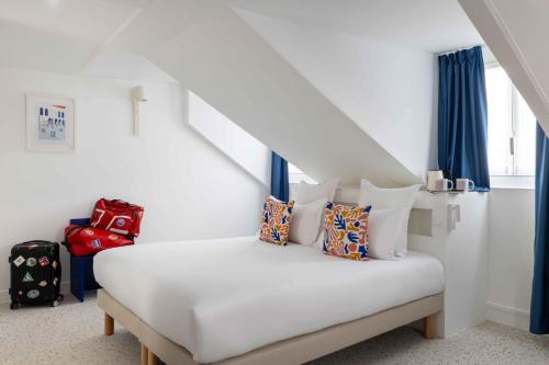 a bedroom with a white bed with blue curtains at Seb & Co in Paris