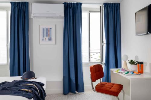 a bedroom with blue curtains and a red chair at Seb & Co in Paris
