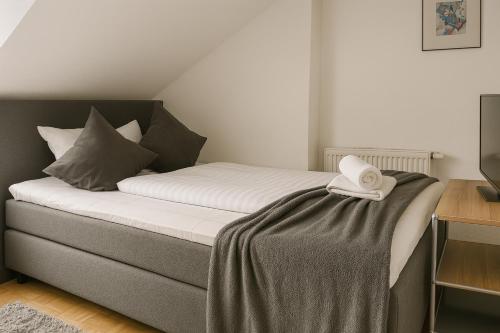 a bed with a white towel on top of it at BoardingHouse - Studios & Apartments in Kassel
