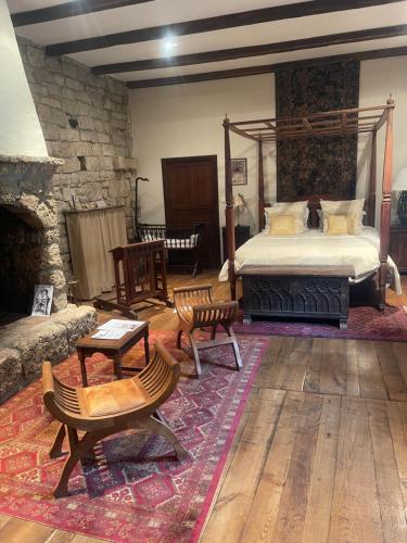 une chambre avec un lit et un mur en pierre dans l'établissement Le Château de Sorgues, à Cornus