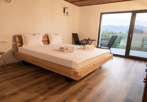 a large bed in a room with a large window at Sunset Hills Chalet in Slănic