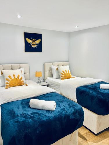 a bedroom with two beds with blue cushions at Folkestone Harbour - 3 Bed sleeps 7 Ground Floor in Dover