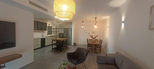 a kitchen and living room with a couch and a table at מרוהטת וחדשה, בין קיסריה לאור עקיבא, 10 דק' מהים in Or ‘Aqīvāh