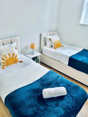 two beds in a room with a blue rug at Folkestone Harbour - 3 Bed sleeps 7 Ground Floor in Dover