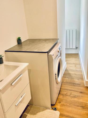 a kitchen with a washing machine and a sink at Folkestone Harbour - 3 Bed sleeps 7 Ground Floor in Dover