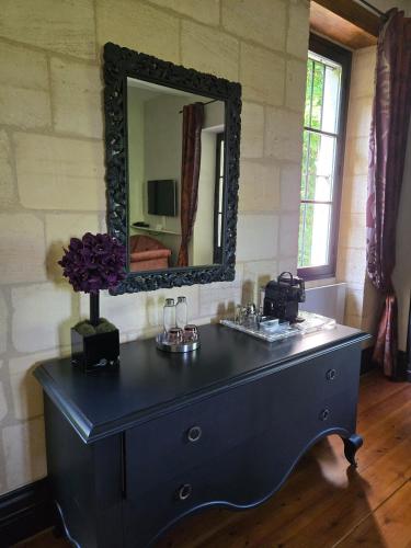 a dresser in a room with a mirror at Château de Courtebotte in Saint-Jean-de-Blaignac