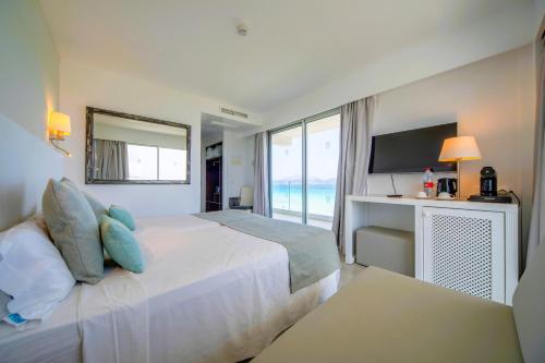 a bedroom with a bed with a view of the ocean at Playa Esperanza Resort Affiliated by Meliá in Playa de Muro