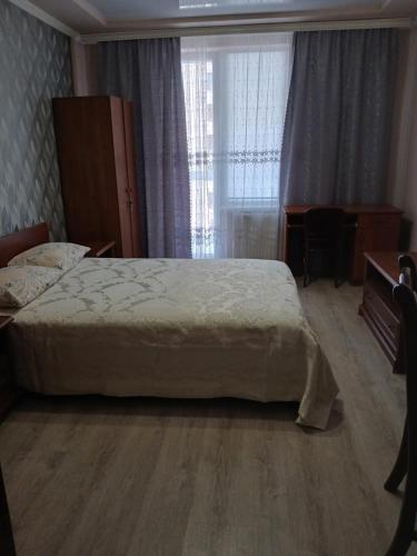 a bedroom with a bed and a desk and a window at Шикарные апартаменты на ул.Княгини Ольги ,100К. in Lviv