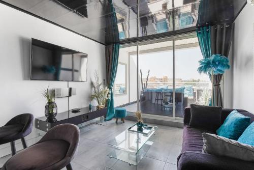 un salon avec un canapé et une grande fenêtre dans l'établissement Village Naturiste R4N - L'Aïna Port Ambonne Luxe, au Cap d'Agde