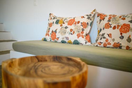 a couch with a pillow and a wooden table at Amorgos Elegant Houses, 6 Villas in Amorgos