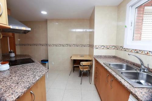 a small kitchen with a sink and a table at Modern apartment in Calafell with sea and mountain view in Calafell