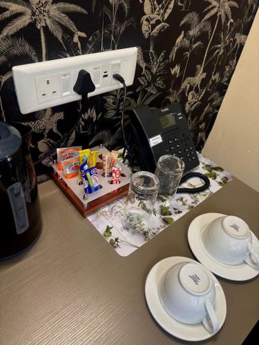 a table with plates and a telephone on it at Aerodrome Lodge and Conference Centre in Benoni
