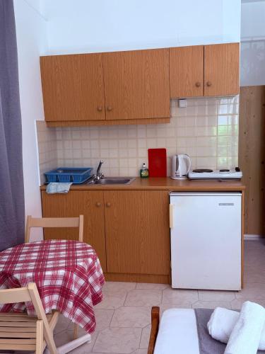 a kitchen with wooden cabinets and a white refrigerator at Argiro's apartment at Agia Galini in Agia Galini
