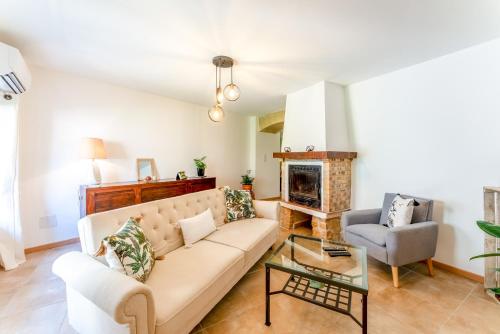 un salon avec un canapé et une cheminée dans l'établissement La Bonbonnière Gîte De Charme, à Malaucène