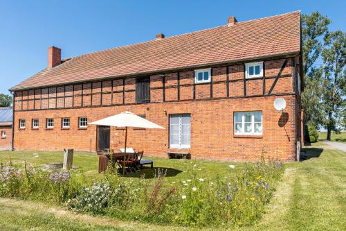 a brick building with an umbrella in front of it at Der Flusshof, Scheunenwohnung in Werben