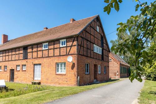 an old brick building with a road in front of it at Der Flusshof, Scheunenwohnung in Werben