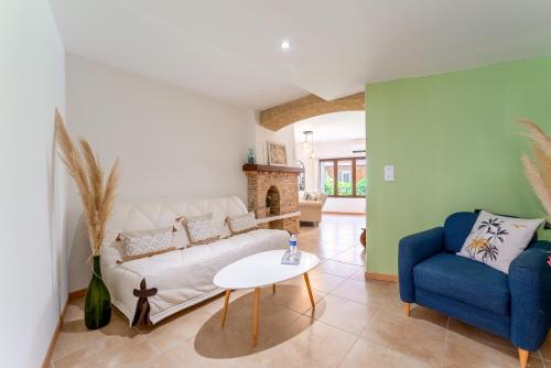 - un salon avec un canapé blanc et une chaise bleue dans l'établissement La Bonbonnière Gîte De Charme, à Malaucène