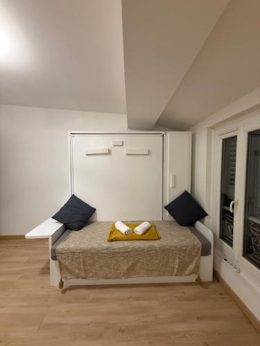 une chambre avec un lit dans une pièce blanche dans l'établissement Charmant studio intra-muros, à Avignon