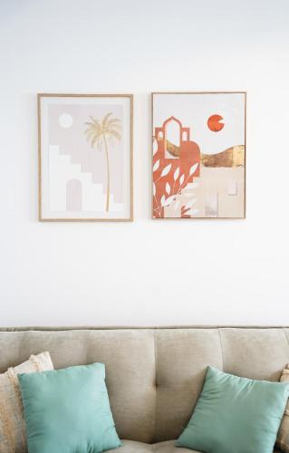 deux tableaux encadrés sur le mur au-dessus d'un canapé dans l'établissement Studio tout confort - En plein centre de Lorient, à Lorient