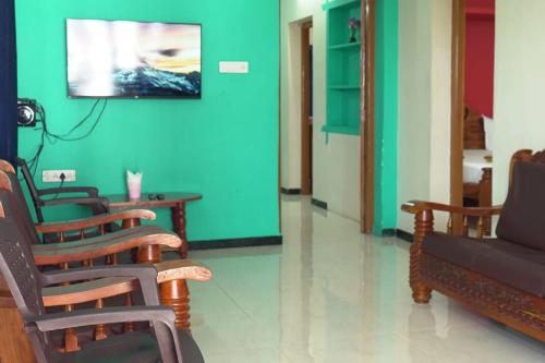 a living room with chairs and a green wall at Red Paradise in Vālpārai