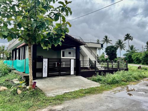 a small house with a tree in front of it at Kannada Maathe Home Stay- 2km to Golden Temple-Tibet camp in Kushālnagar