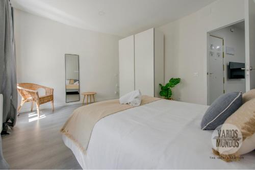 Un dormitorio blanco con una cama grande y una silla. en Descubre Madrid para 5, al pie de Gran Vía E2, en Madrid
